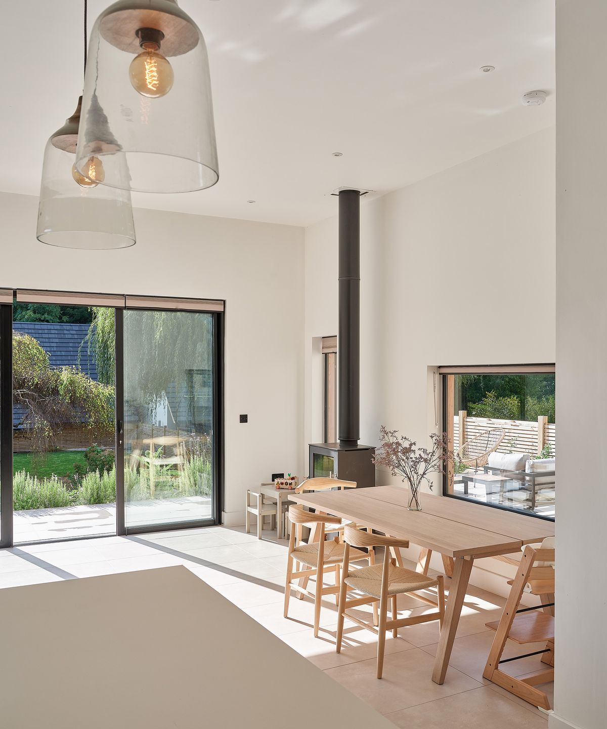 A scandi style dining room with wooden table and black woodburning stove