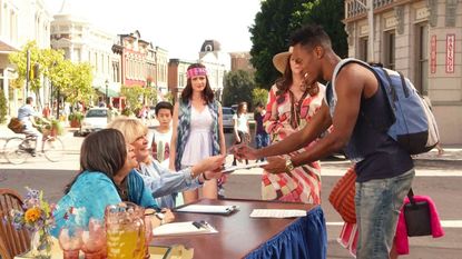 Scene from 'Gilmore Girls', young black man being handed a form to complete by two older ladies