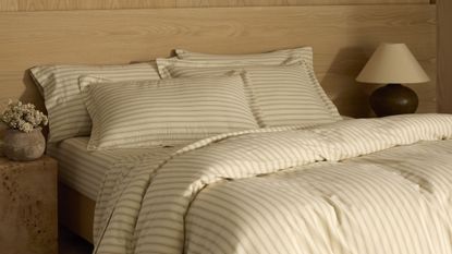 Cozy Earth Soft-Wash Bedding in Coconut/Sandalwood Ticking Stripe pictured in a neutral bedroom area featuring a burl wood side table and oversized natural grain headboard