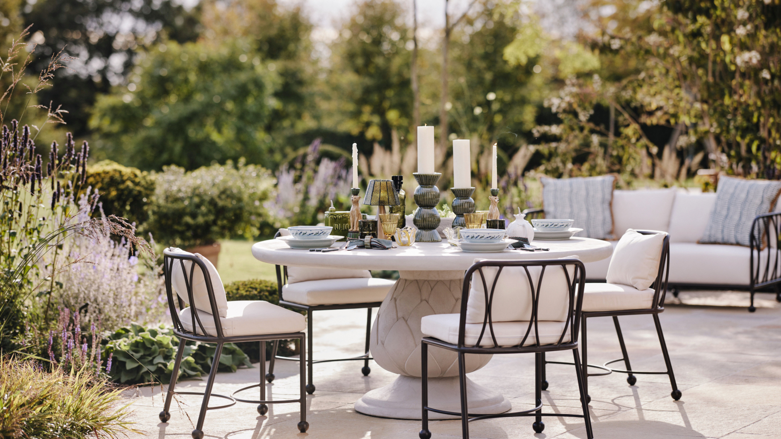 patio with dining table and chairs, sofa and planted borders