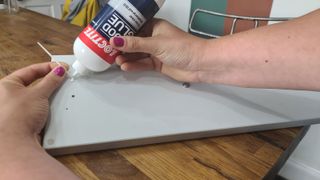 inserting a tooth pick into a kitchen drawer with some wood glue into the holes