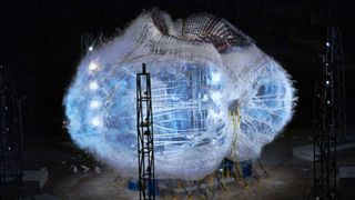 a balloon-like habitat stretched to its limit inside a dark facility