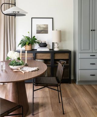 A black and mid-toned wood sideboard in a dining room