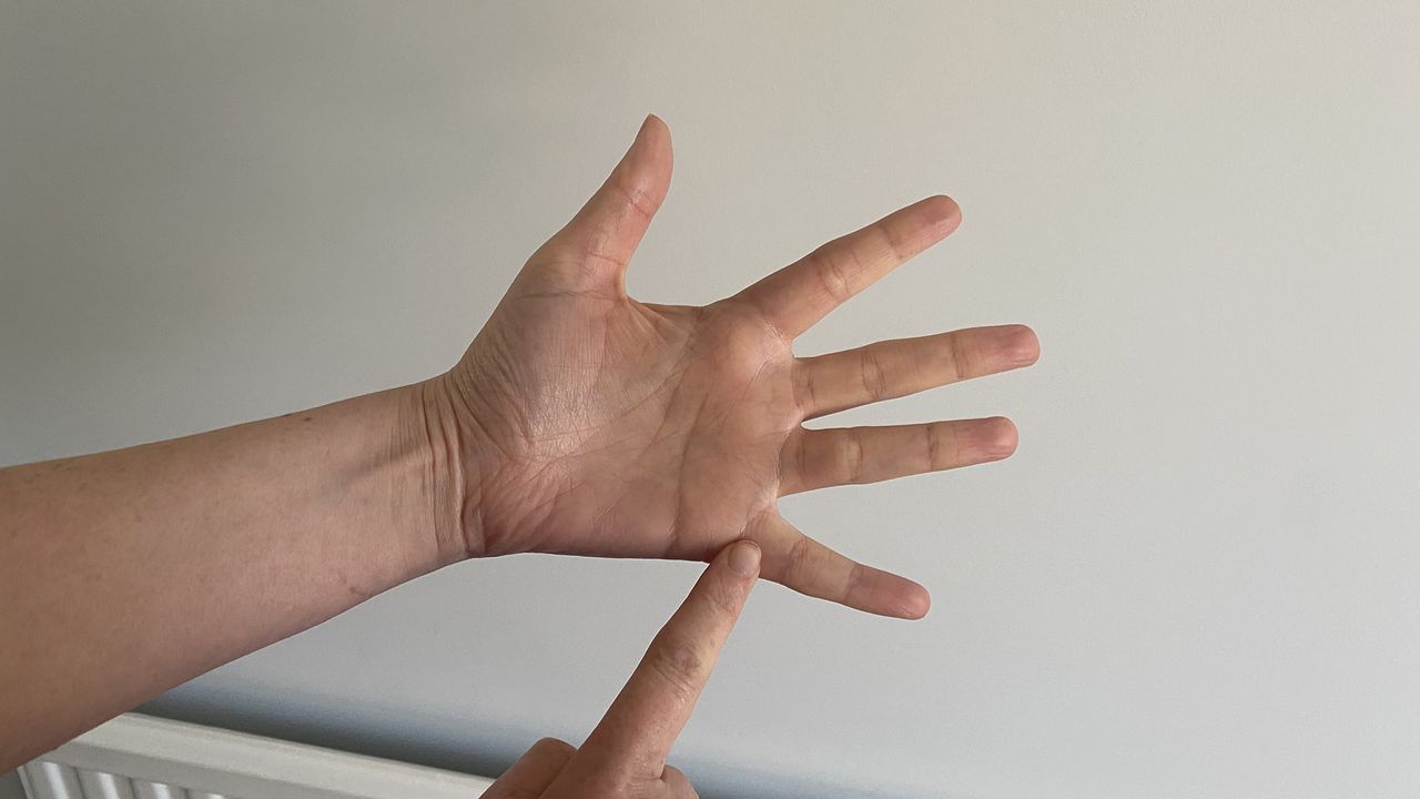 A close up of two hands using the finger breathing relaxation for technique, with the trace finger resting at the base of the pinky finger