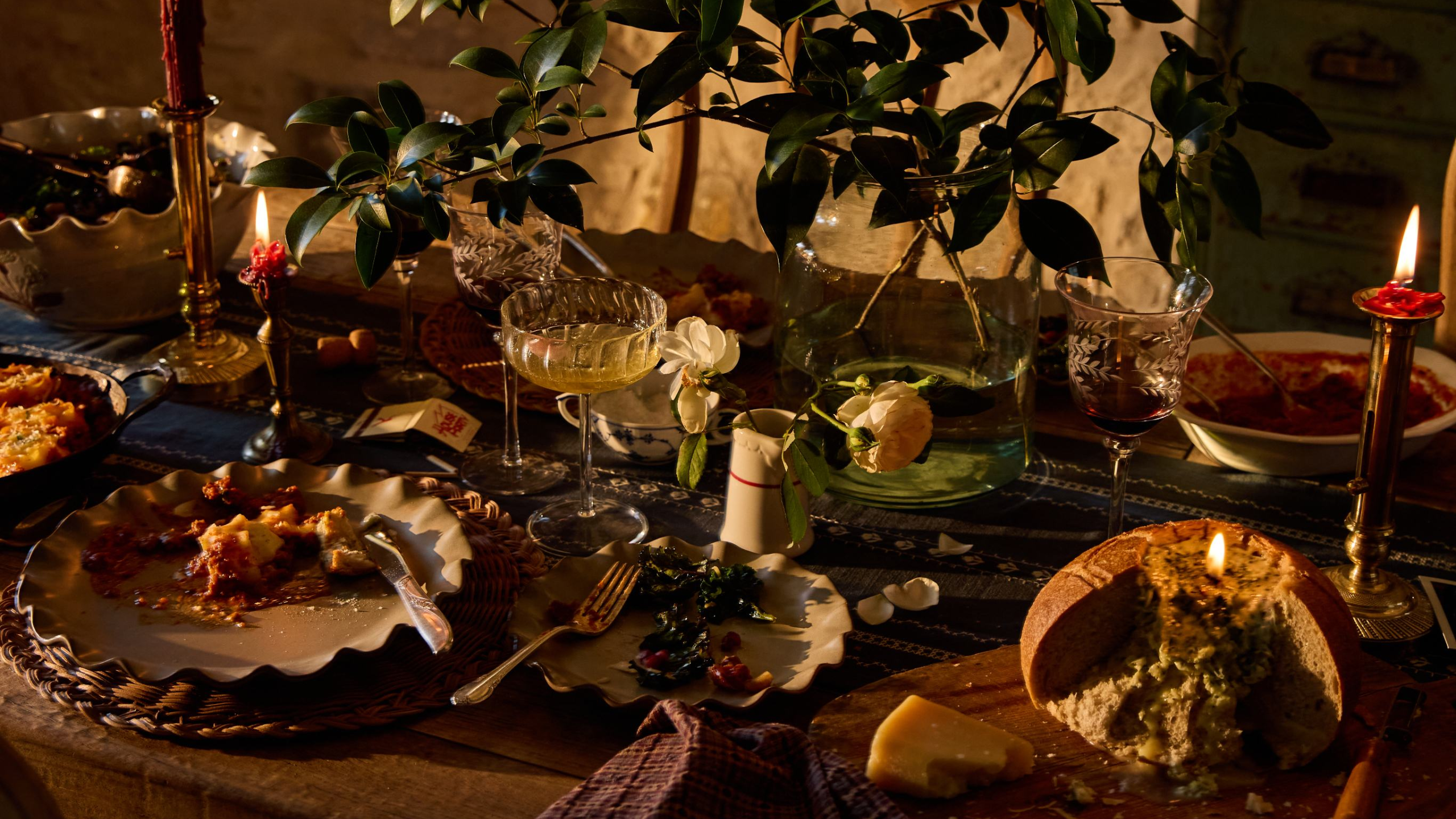 Layered, heirloom-inspired Thanksgiving tablescape featuring ruffled stoneware plates, woven chargers, brass candlesticks, and tapestry-inspired napkins from Magnolia's Thanksgiving 2026 collection
