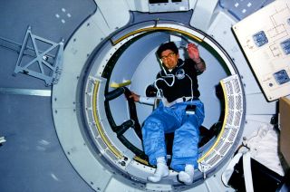 Payload specialist Lodewijk van den Berg enters the tunnel leading from space shuttle Challenger's mid-deck to the Spacelab module during the STS-51B mission in May 1985.