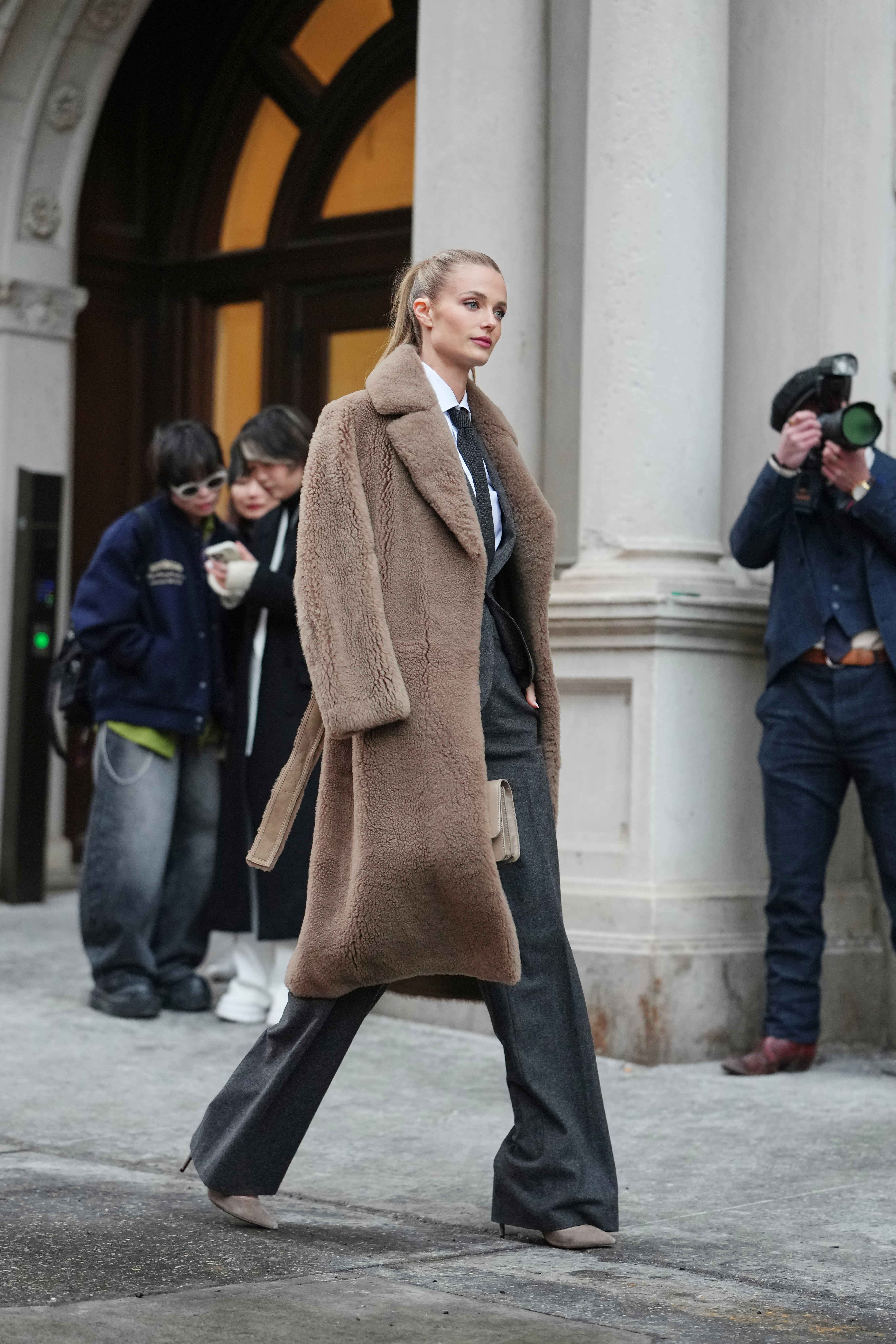 woman wearing teddy coat, necktie, trousers and heels
