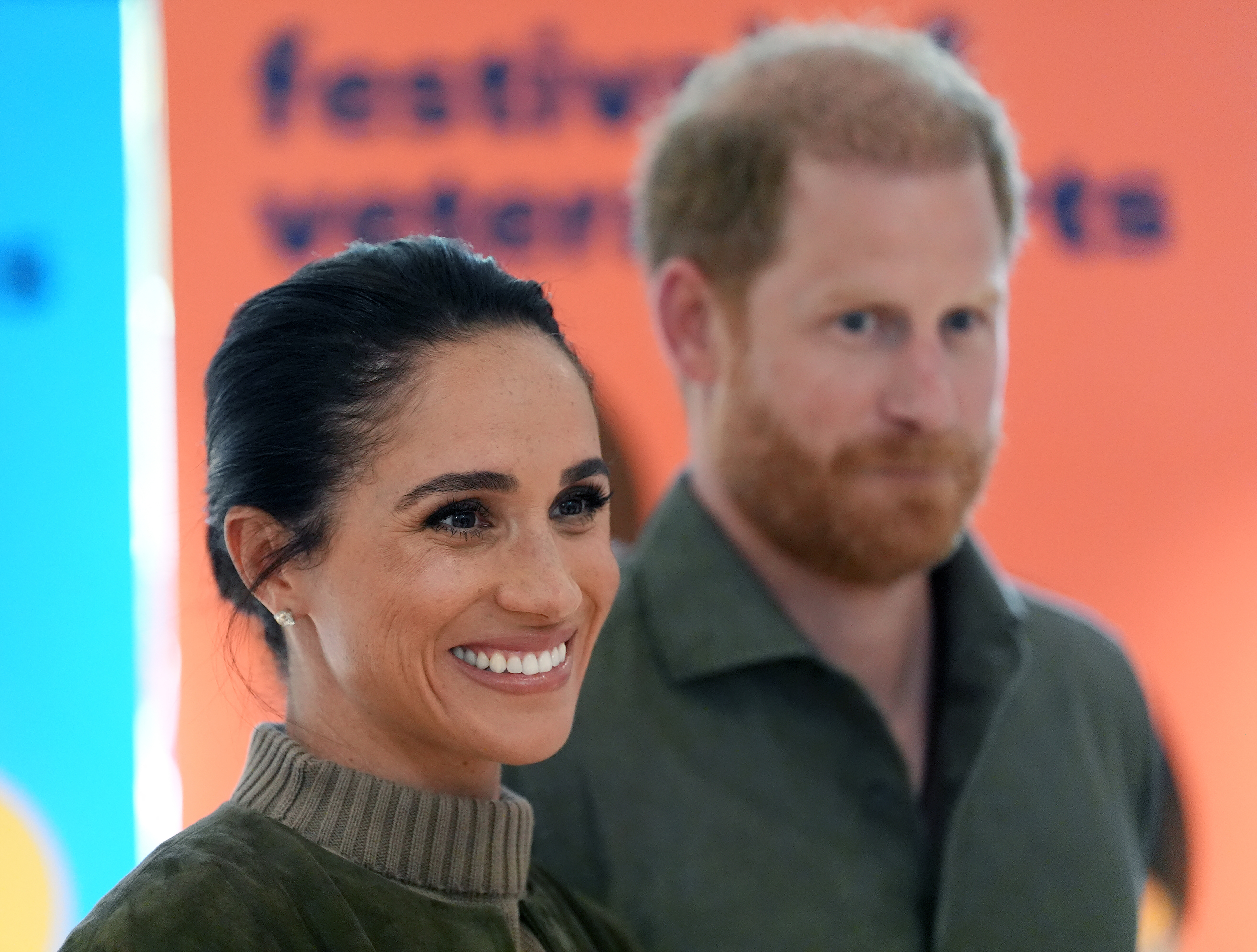 Meghan Markle and Prince Harry standing next to each other and smiling