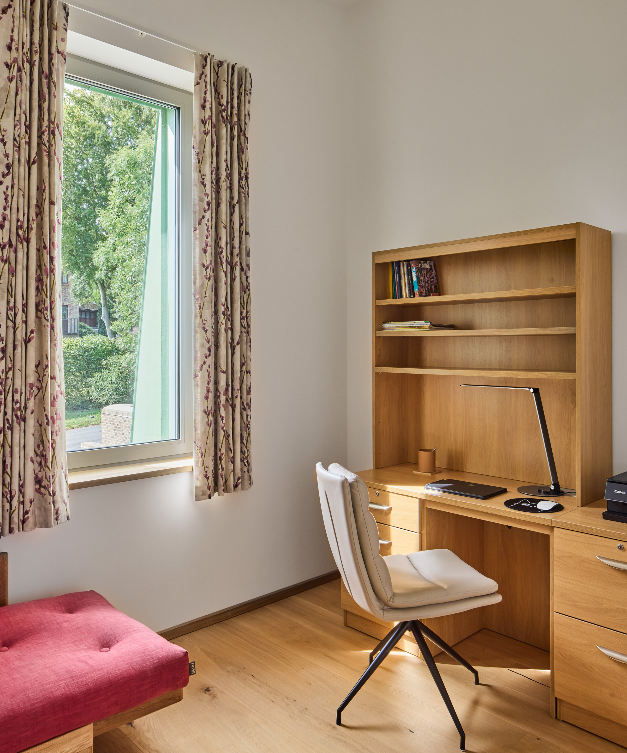 Office with wooden desk and window to the left hand side