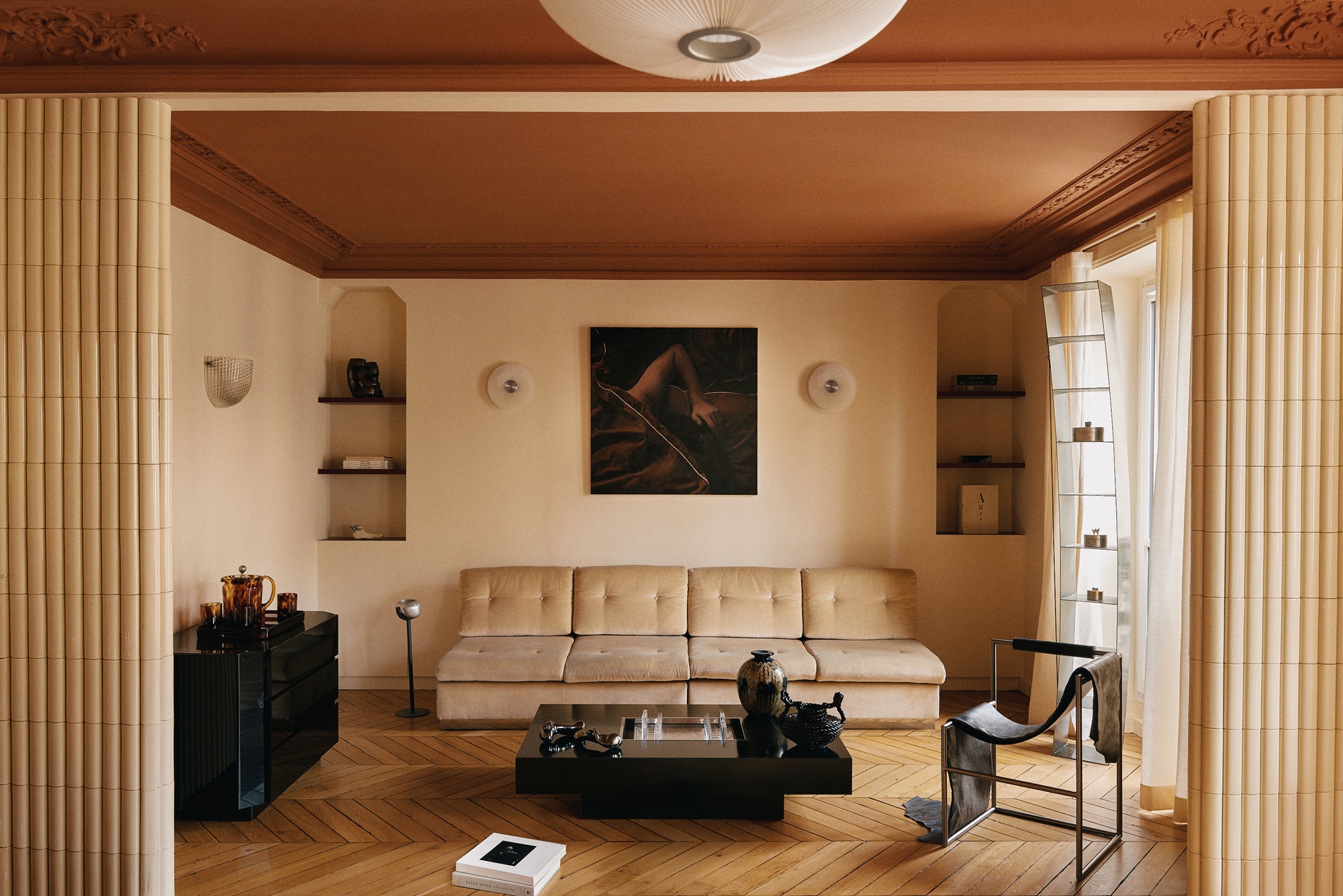 A living room with a terracotta painted ceiling with a beige sofa