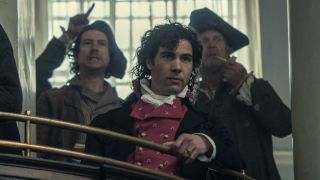 Tahar Rahim leans on a railing in observation in Napoleon.