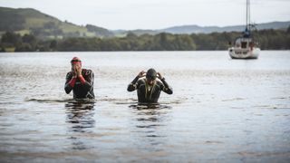 Two men in wetsuits swimming Lake Windermere