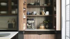 pocket doors conceal wooden drawers and cabinetry with coffee machine and other appliances within