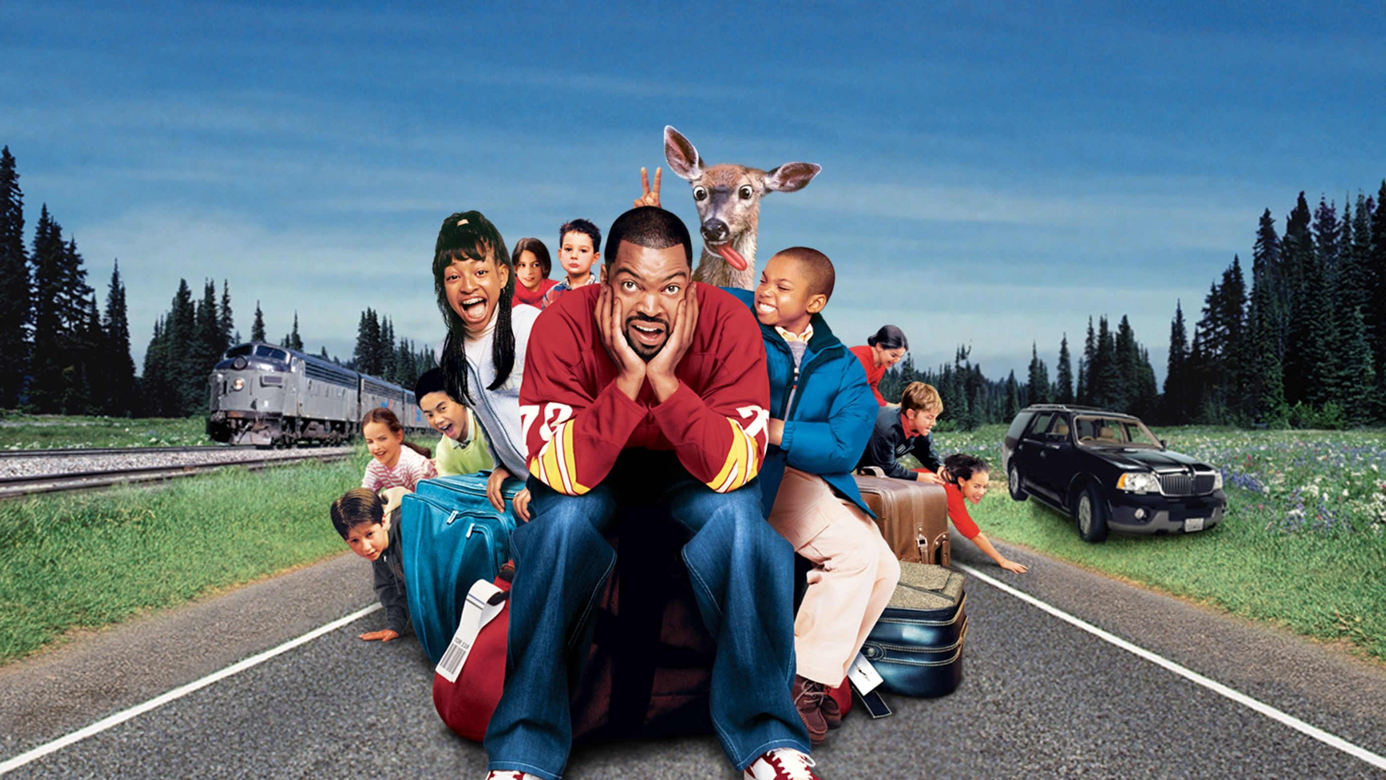 Hela gänget i komedifilmen Are We There Yet? sitter tillsammans ute på en väg i skogen.