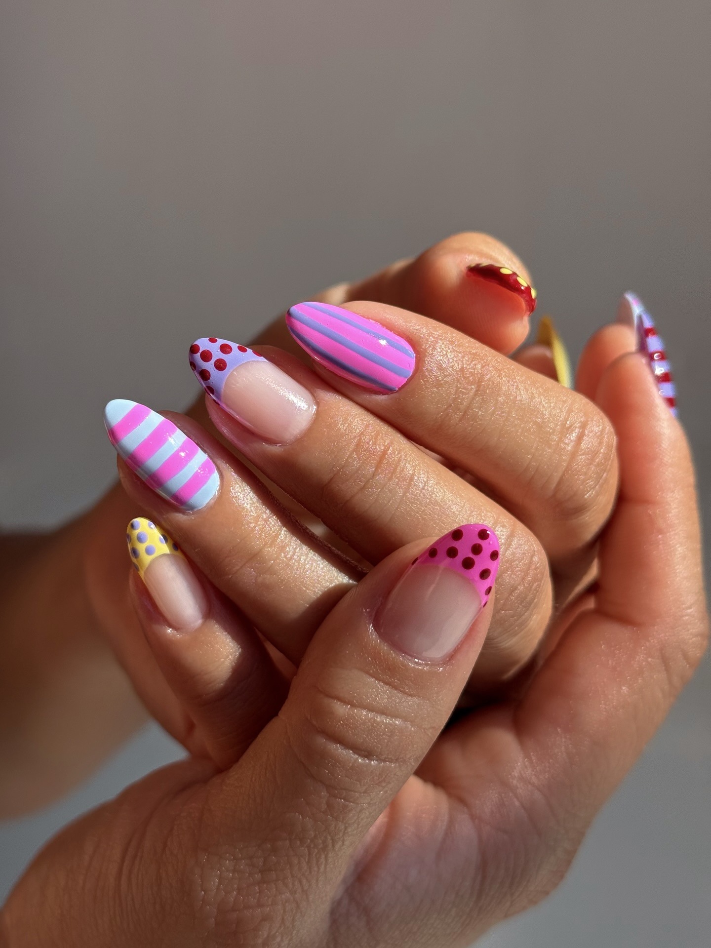 A colourful nail art look with spot and stripe detailing