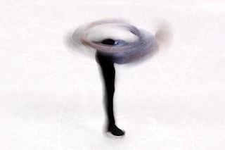 A long-exposure photo shows Adam Rippon whirling on the ice during the figure skating team event.