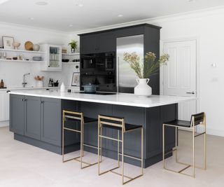 black and white kitchen with island unit topped in white stone