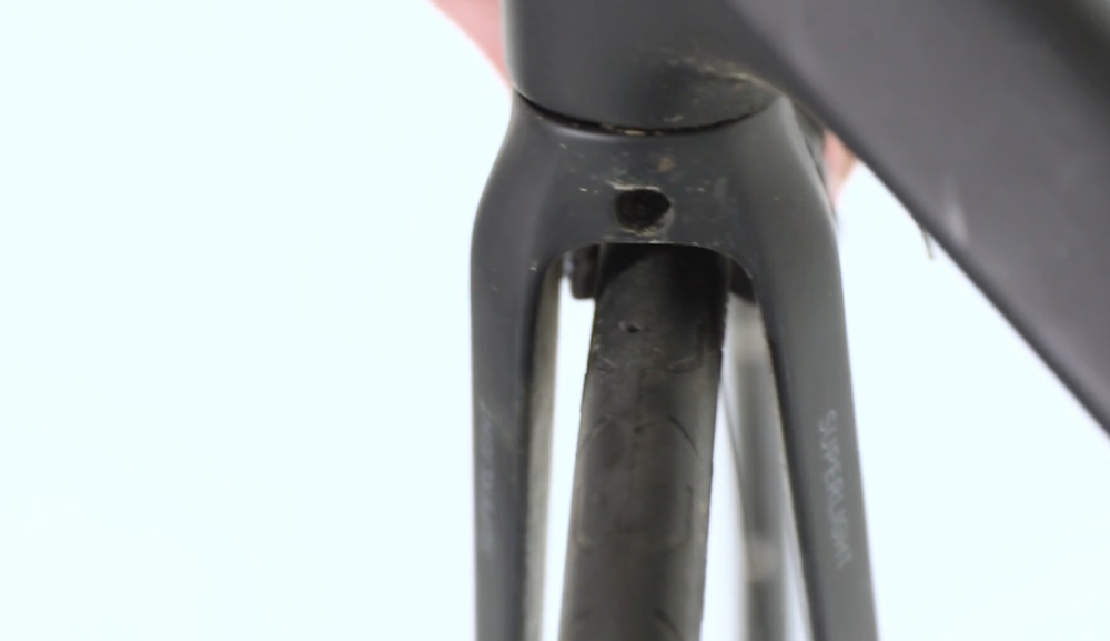 the caliper retaining bolt behind the fork.