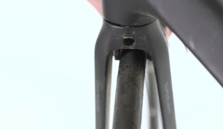 the caliper retaining bolt behind the fork.