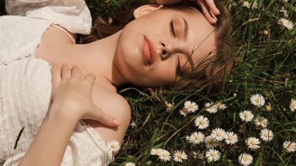 A woman lying in the grass considering beingi in an open relationship