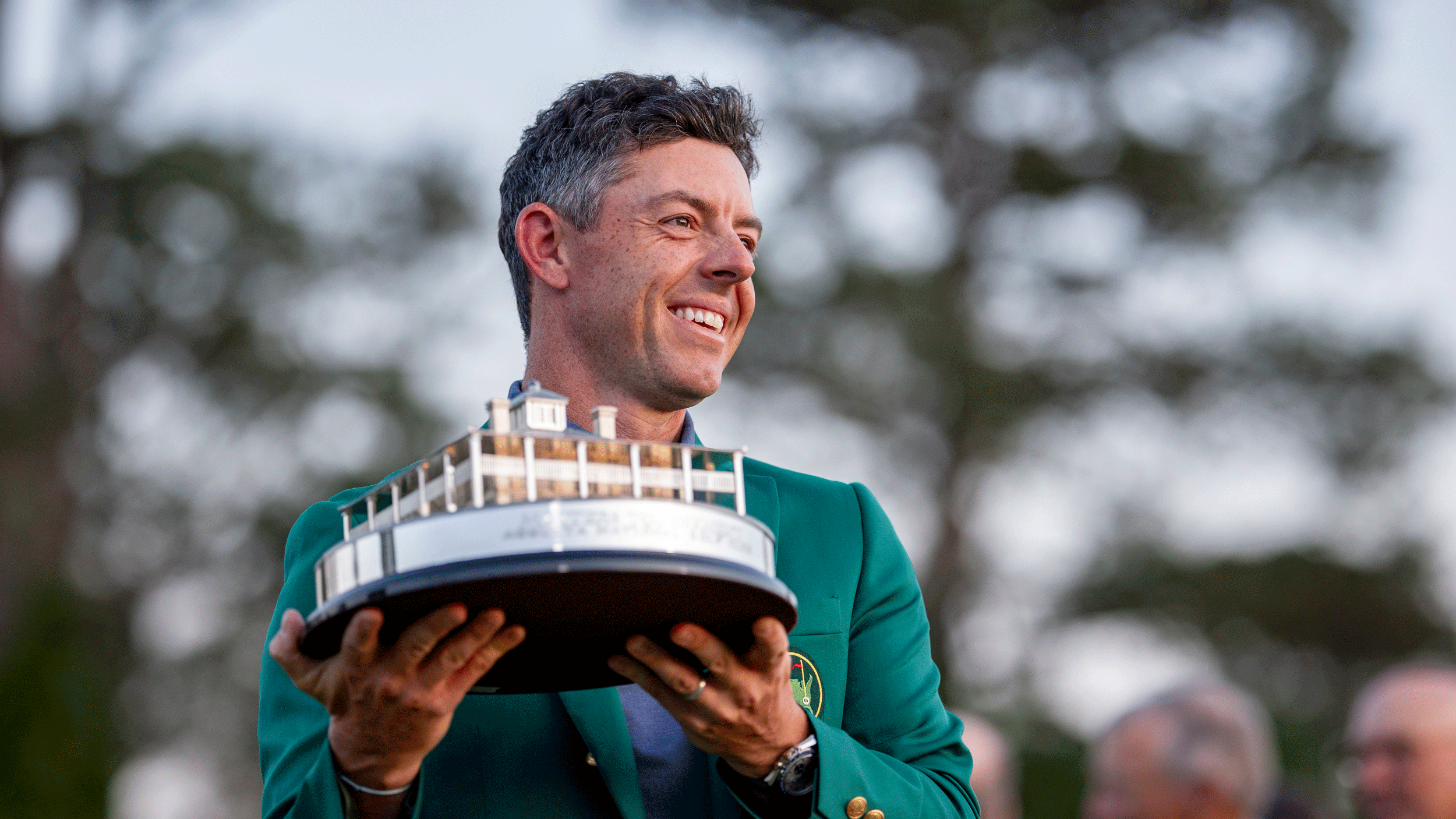 Rory McIlroy smiles while holding up The Masters trophy following his victory at Augusta National in 2025