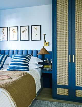 Blue bedroom with padded headboard and fitted wardrobe painted blue