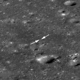 Chang’e-4 lander (near tip of left arrow) and rover (right arrow) among craters on the floor of Von Kármán crater in a 1,700-meter-wide image.