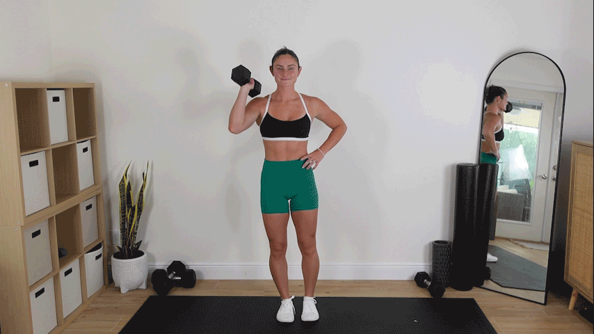 trainer Kirra Mitlo doing dumbbell single arm front rack marches