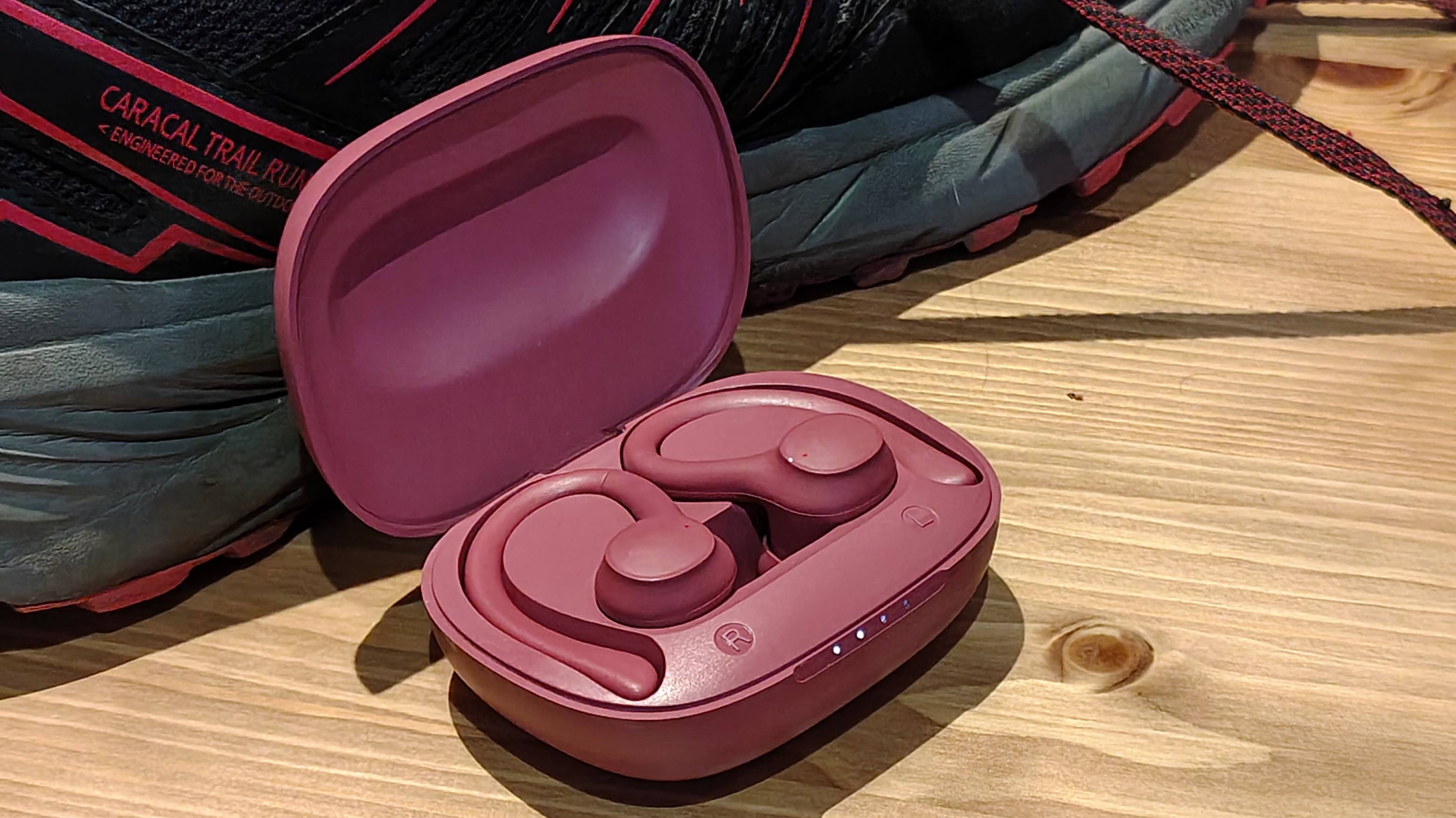 The Balco Sports Earbuds case and buds next to some shoes.