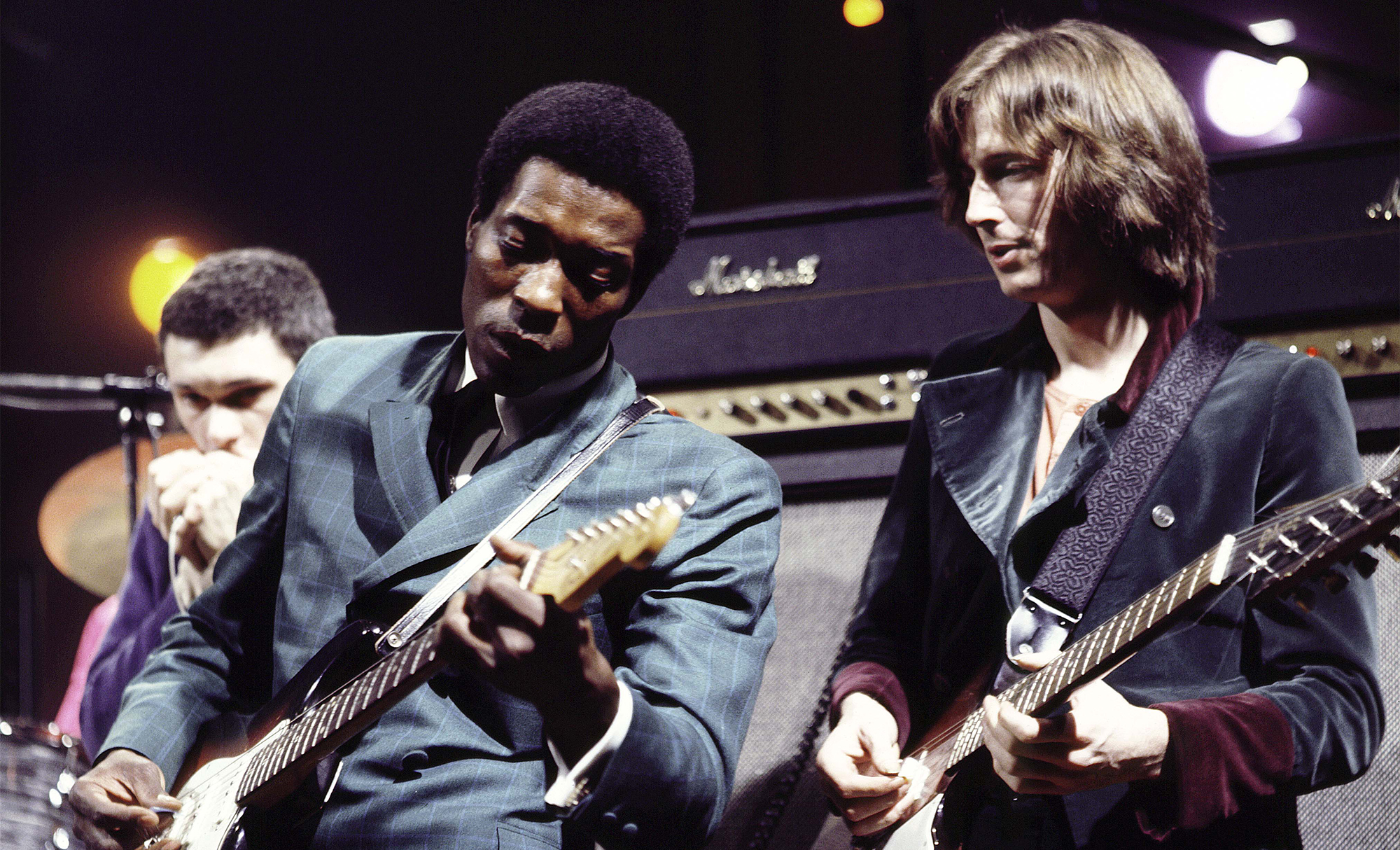 American guitarist Buddy Guy (left) performs live on stage with English guitarist Eric Clapton at the Supershow session at a disused factory in Staines, England on 26th March 1969. Eric Clapton plays a 1964 Gibson Firebird guitar.