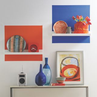 painting vibrant squares with shelf on wall and vases with painting frame on wall