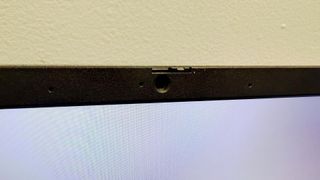 Close up of the webcam on the bezel of the Acer Chromebook Plus Enterprise 515, on a black desk against a white background.