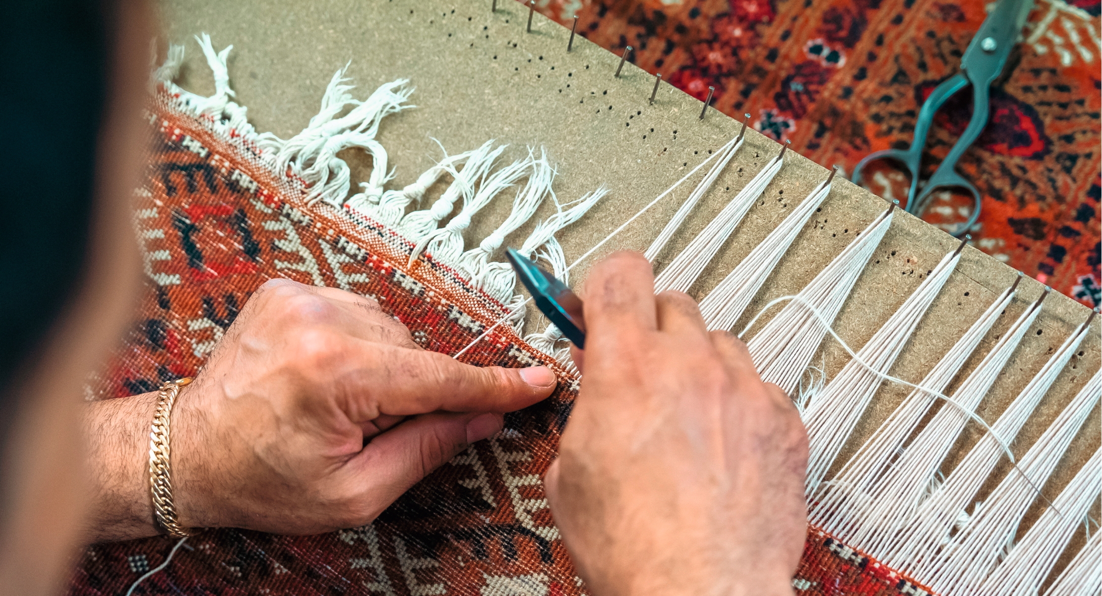 A man repairs the fringe of a turkmen rug