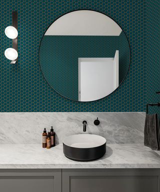 dark teal small tiled effect wallpaper in bathroom with large mirror and black sided sink on white countertop