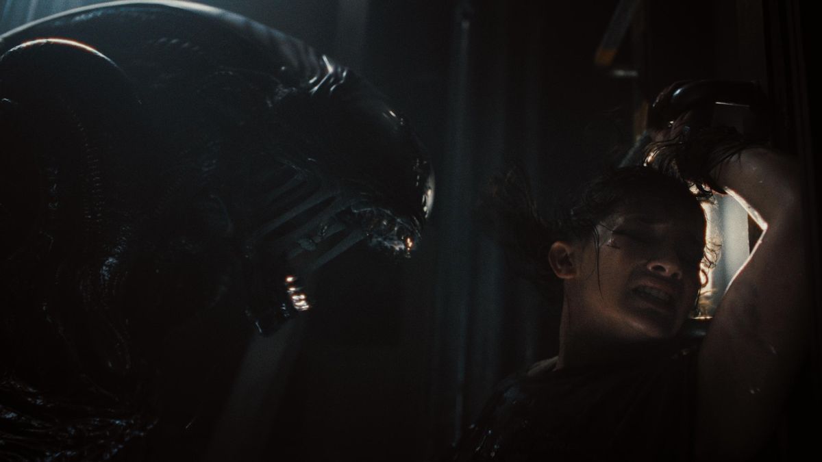 Still from the sci-fi space horror &quot;Alien: Romulus&quot;. Here a woman comes face to face with a scary xenomorph alien.