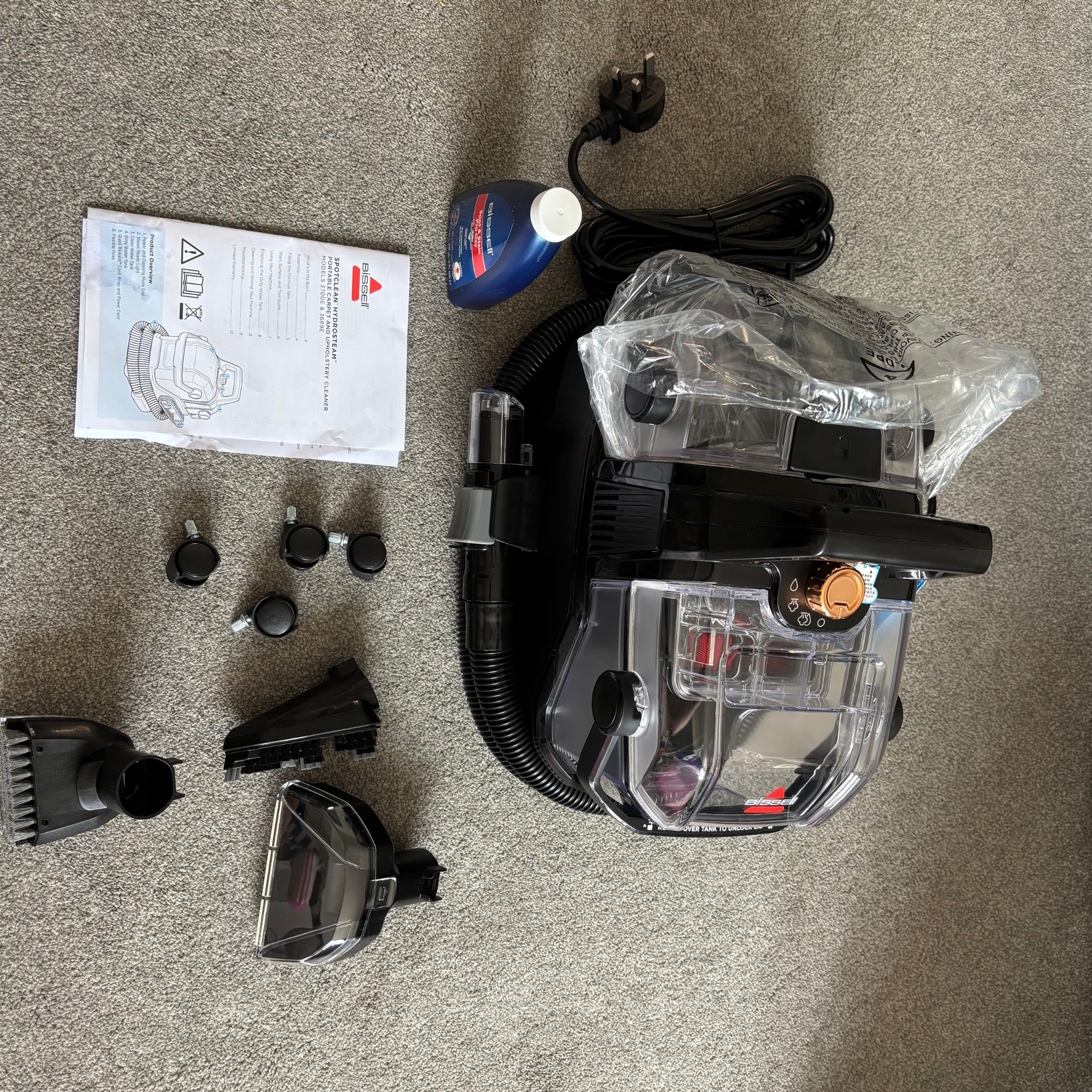 Flat lay of Bissell SpotClean HydroSteam and accessories out of box
