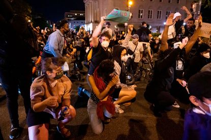 Protesters in D.C. brace themselves under military helicopters