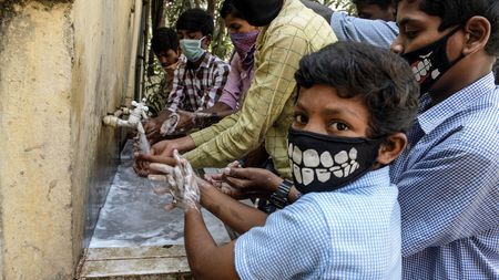 Indian children with facemasks wash their hands © NOAH SEELAM/AFP via Getty Images