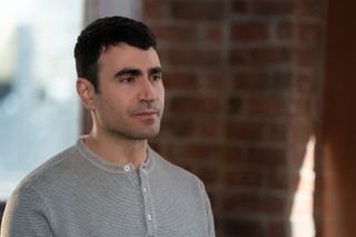 Brett Goldstein as Louis, standing in front of a window and brick wall, in 'Shrinking'