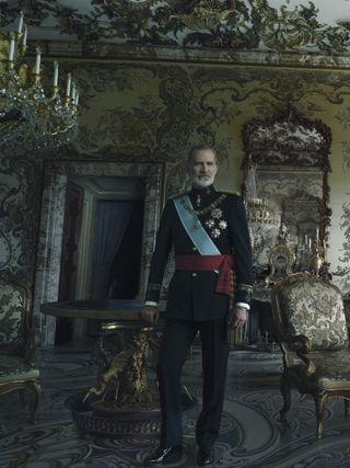 King Felipe wearing a military uniform standing in front of a table and gilded chairs in the Spanish palace