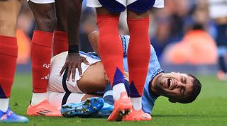 Manchester City's Rodri is comforted by Arsenal players after suffering a serious injury in a Premier League game in September 2024.