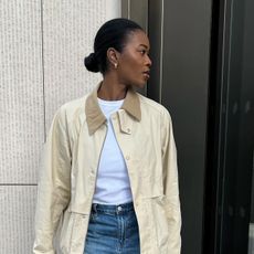 @nlmarilyn wearing a cream barn jacket with a white t-shirt and jeans.