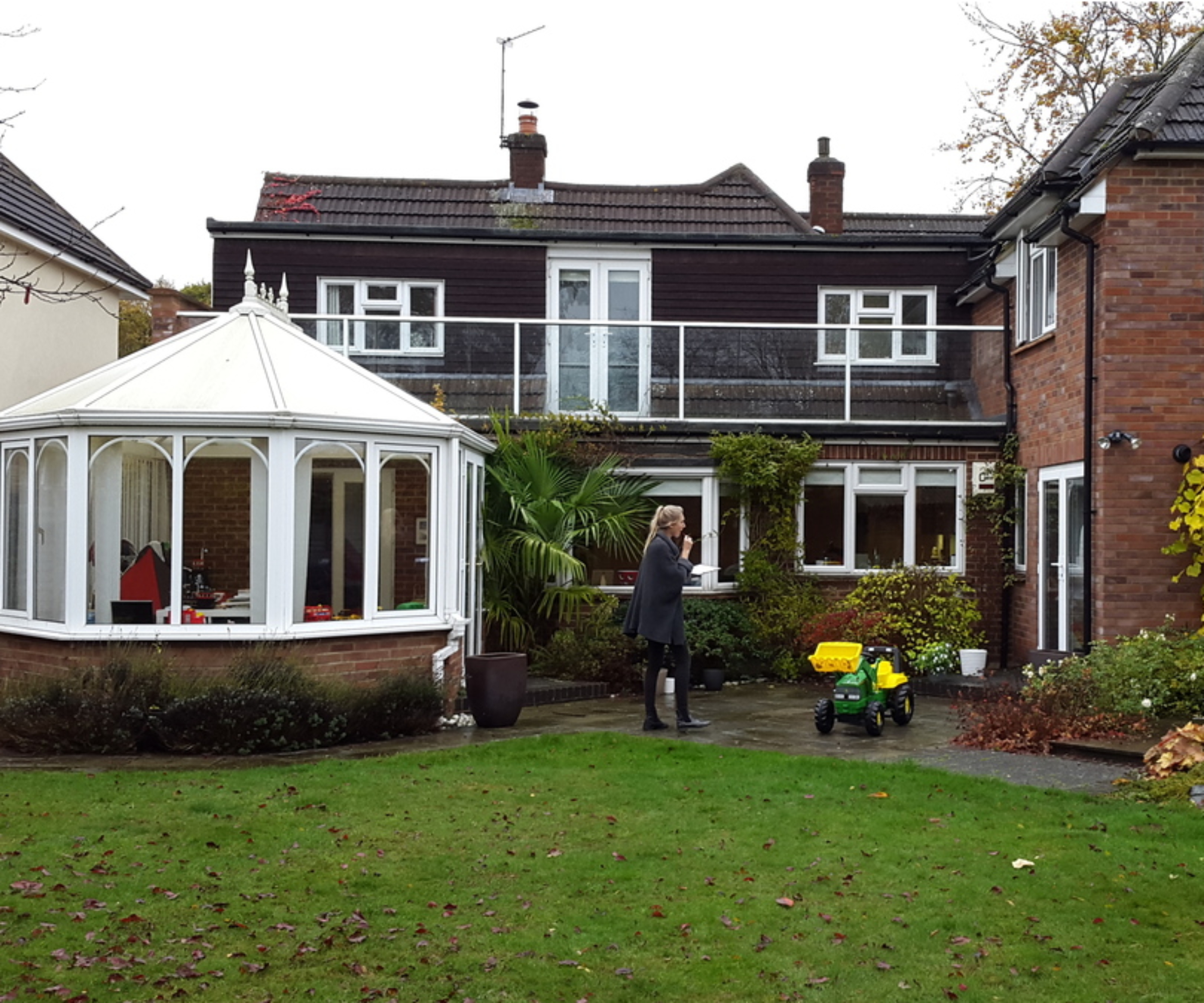 before shot of large house with double storey extension, white conservatory and balcony