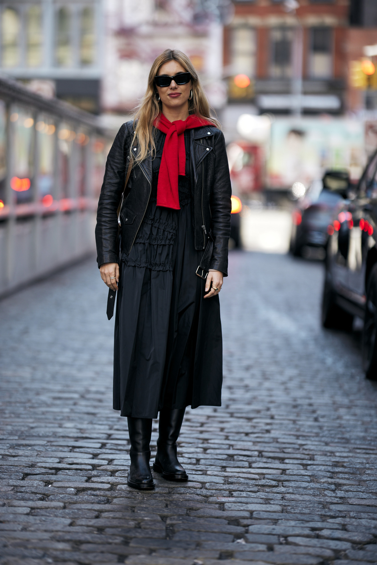 woman wearing a red cardigan, a leather jacket, a black skirt, and boots