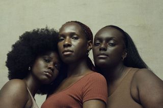 Three black women stand close together