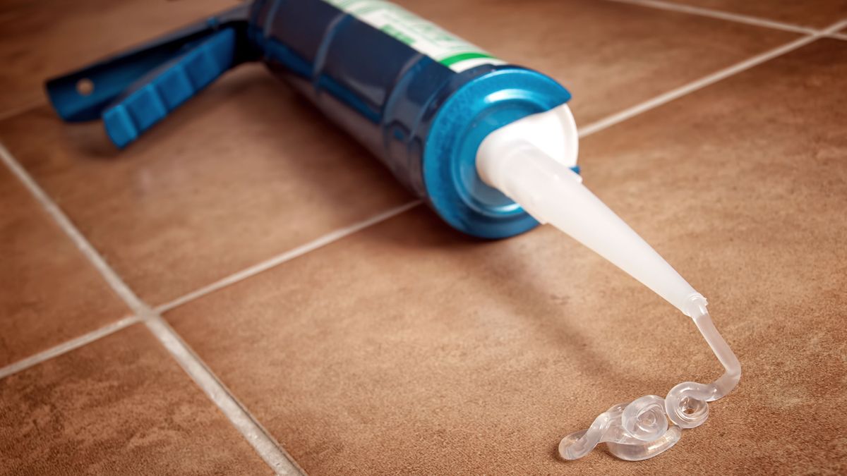 Close up of caulking gun on tiles