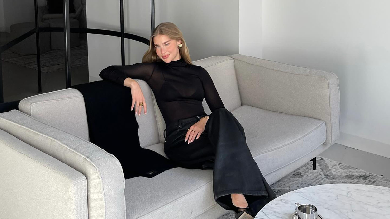 Jess hunt in all black on a sofa