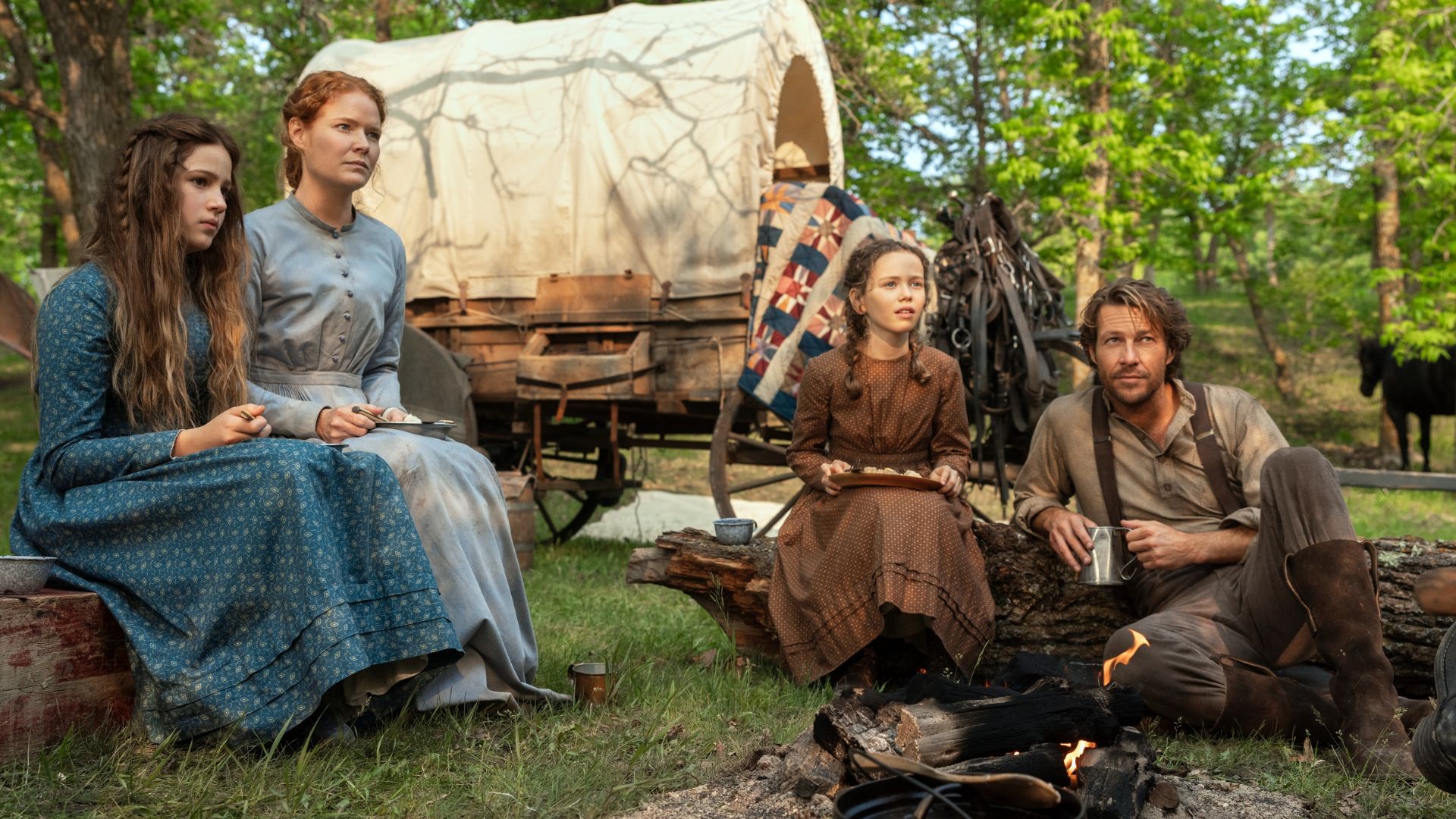 The Ingalls family sit outside their wagon