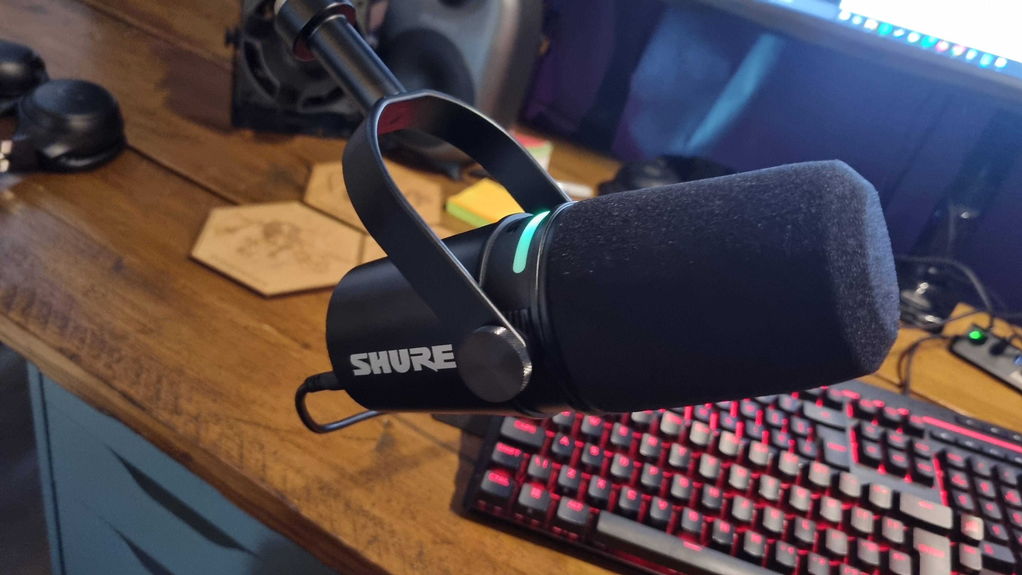 The Shure MV7+ Podcast Microphone attached to a boom arm