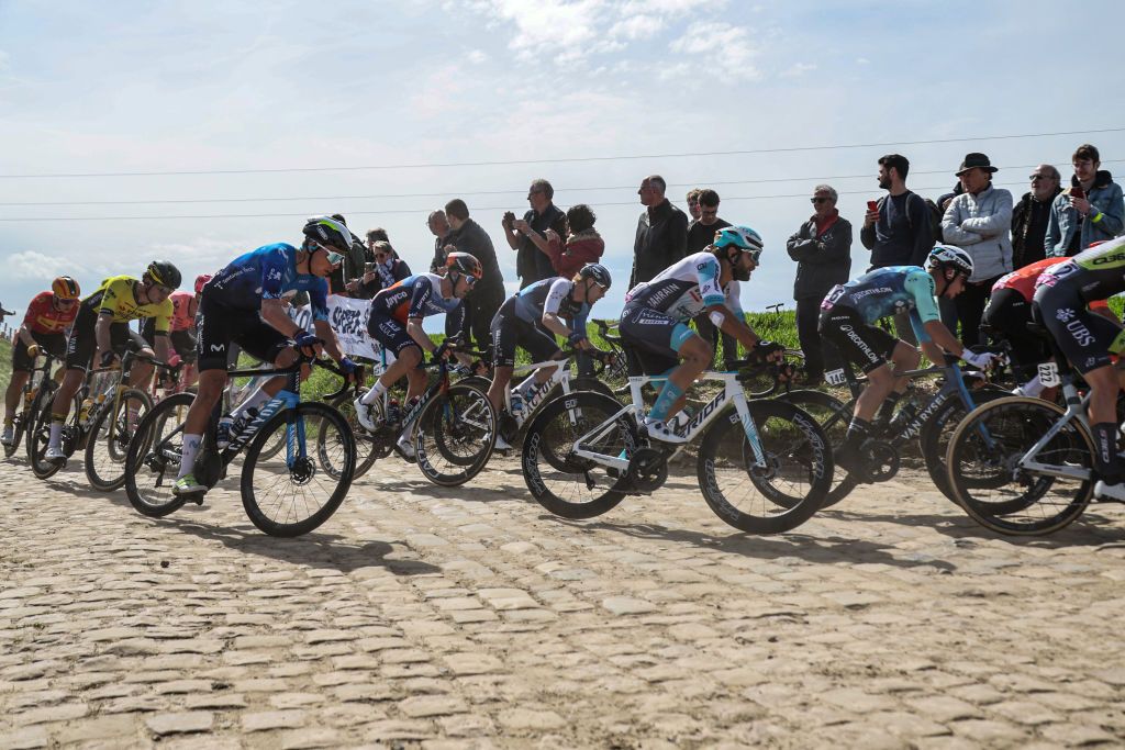 The pack of riders cycles over the cobblestone sector 29 during the 121st edition of the Paris-Roubaix one-day classic cycling race, 260km between Compiegne and Roubaix, northern France, on April 7, 2024. (Photo by Francois LO PRESTI / AFP)